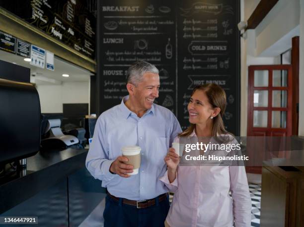 happy adult couple on a date buying a cup of coffee at a cafe - leaving restaurant stock pictures, royalty-free photos & images