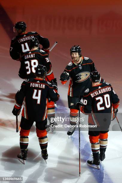 Luke Gane high fives Cam Fowler of the Anaheim Ducks prior to the first period against the Winnipeg Jets at Honda Center on October 13, 2021 in...