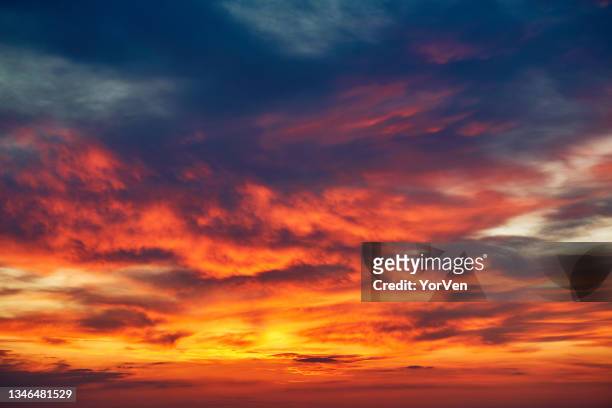 sonnenuntergang mit orangefarbenen wolken über den bergen - sunset stock-fotos und bilder