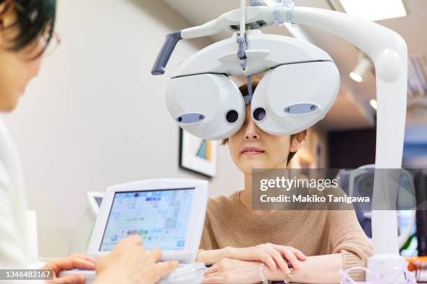 woman getting her eyesight measured to buy glasses - sehkraft stock-fotos und bilder