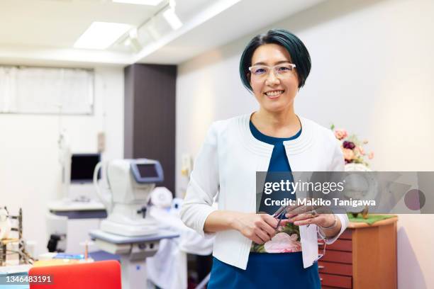 portrait of a female manager of an glasses store - eye test equipment fotografías e imágenes de stock