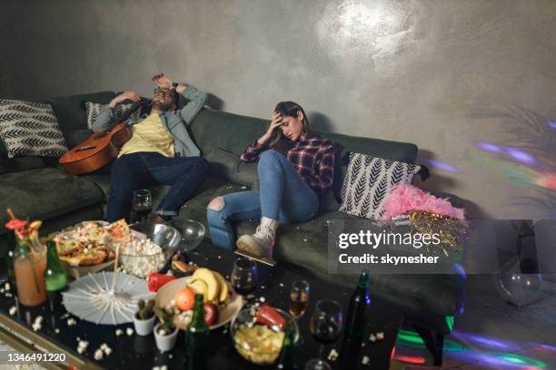 pareja borracha que tiene resaca después de la fiesta en casa. - room after party fotografías e imágenes de stock