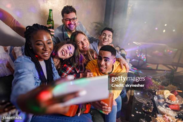 cheerful friends taking a selfie at home party. - messy living room stock pictures, royalty-free photos & images
