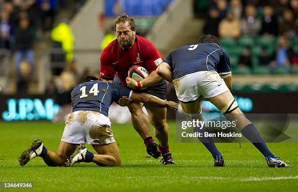 Peter Edwards of the Northern Hemisphere is tackled by Atun Masun and Jeremy Thrush of the Southern Hemisphere during the Help For Heroes Rugby...