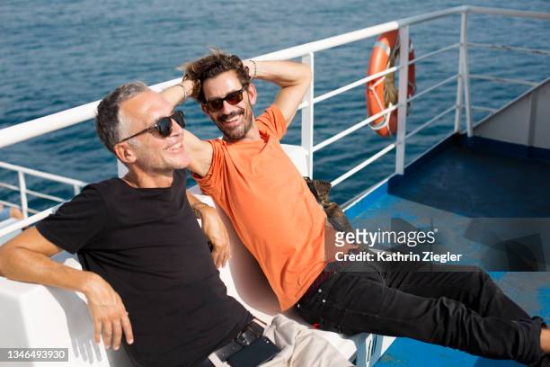 two happy men traveling on a ferry boat - fähre stock-fotos und bilder