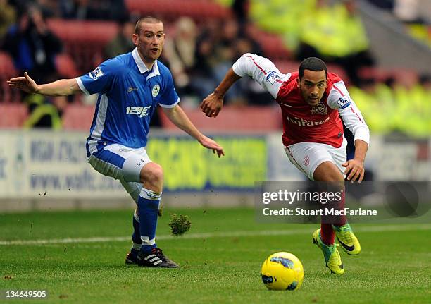 Theo Walcott of Arsenal breaks past David Jones of Wigan during the Barclays Premier League match between Wigan Athletic and Arsenal at DW Stadium on...