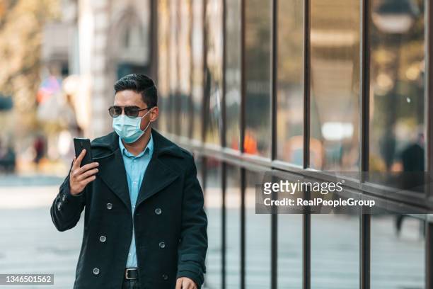 business man using his cell phone on the street. - surgical mask man stock pictures, royalty-free photos & images
