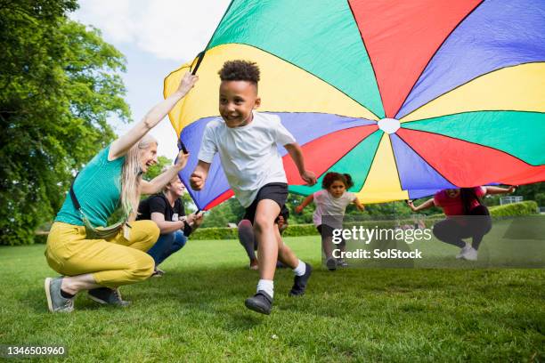 パラシュートを持つ学童 - preschool child ストックフォトと画像