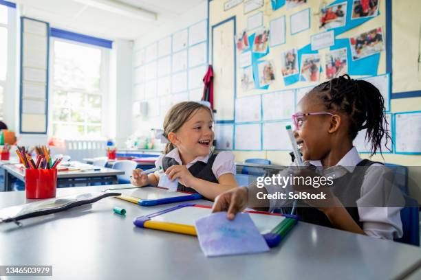 girls having fun at school - uniform werk stockfoto's en -beelden