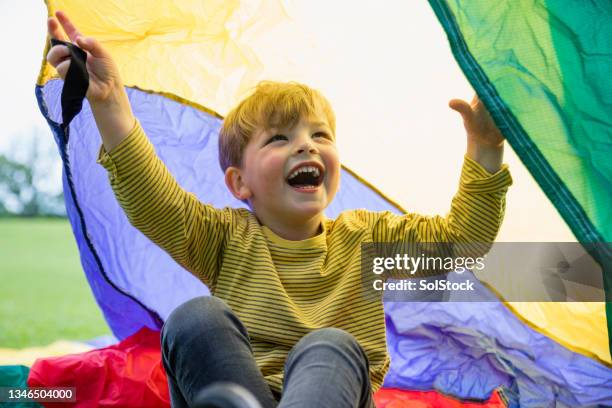 sitting under the parachute - boys playing stock pictures, royalty-free photos & images