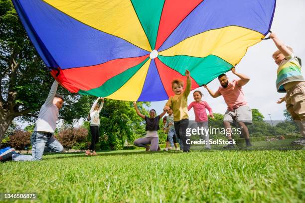 preschool parachute time - kindergarten children stockfoto's en -beelden