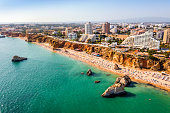 Aerial view of touristic Portimao with wide sandy Rocha beach, Algarve, Portugal