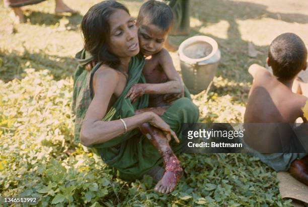 Woman holds an injured child on a roadside close to the border with East Pakistan following shelling by Pakistani Army during the Bangladesh...