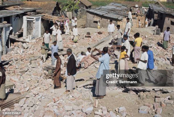 Victims of shelling search for their belongings amid the ruins of their homes following attacks by guerillas during the Bangladesh Liberation War in...