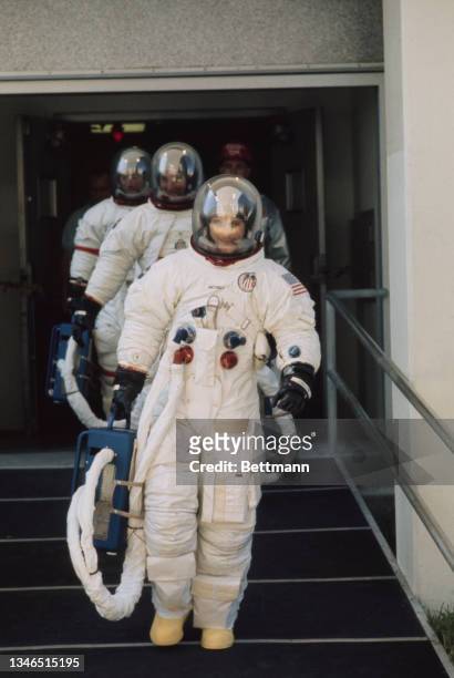 American NASA command module pilot Ken Mattingly, followed by American NASA lunar module pilot Charles Duke, and American NASA mission commander John...
