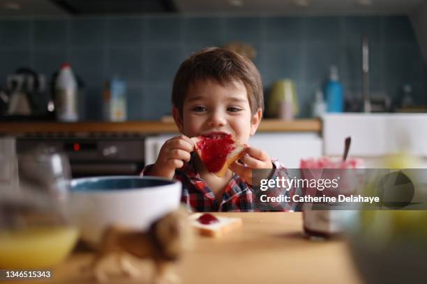 a little girl having his breakfast - marmelade stock-fotos und bilder