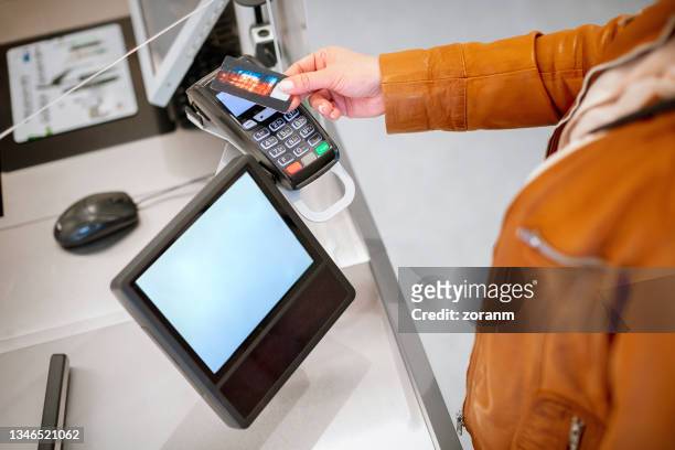 bezahlen per kreditkarte kontaktlos am lesegerät, unterschriftenblock am schalter - convenience store counter stock-fotos und bilder