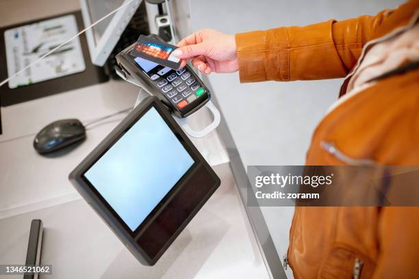 paying by credit card contactlessly on the reader, signature pad on the counter - convenience store counter stockfoto's en -beelden