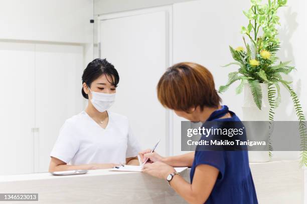 dental hygienist and a patient at the reception - schwesterntisch stock-fotos und bilder