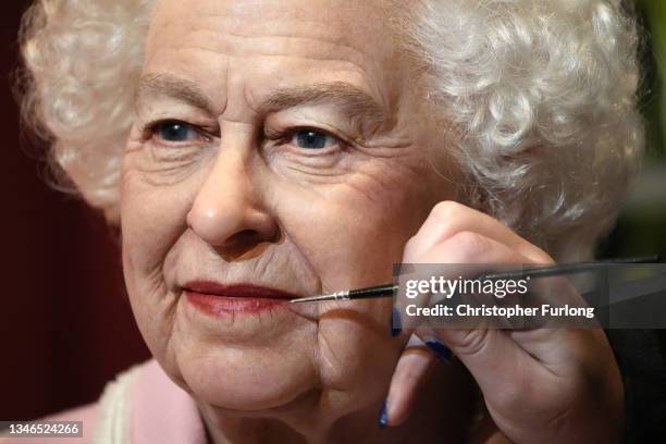 Artist Emma Meehan applies final touches on a new waxwork of Queen Elizabeth II at Madame Tussauds, Blackpool, on October 14, 2021 in Blackpool,...