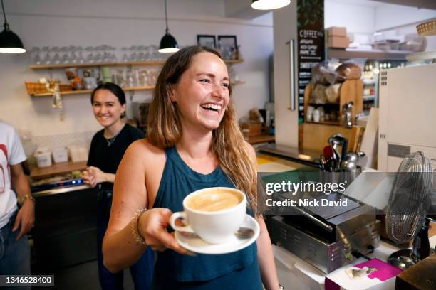 a smiling waitress serving a coffee - cafe owner fotografías e imágenes de stock