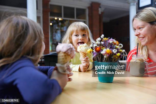a young family enjoying time together at a local cafe - royal tunbridge wells stock pictures, royalty-free photos & images