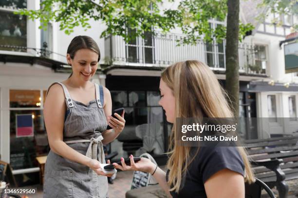 a waitress taking a contactless payment from a customer - waitress stock pictures, royalty-free photos & images