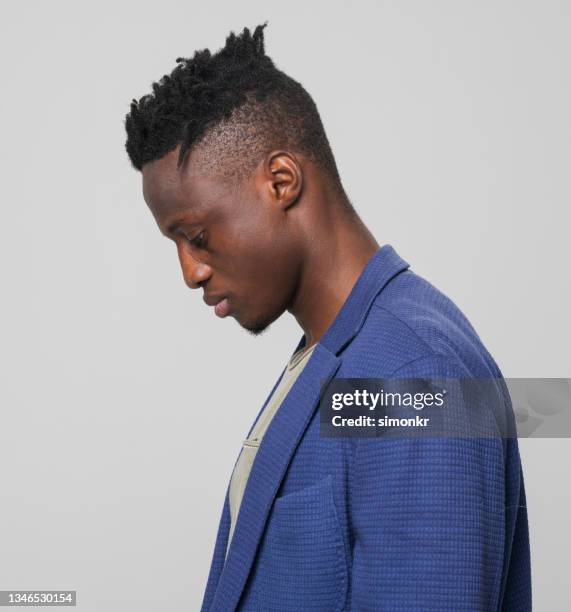 profile of thoughtful young businessman looking down - omlaag kijken stockfoto's en -beelden