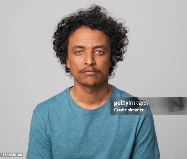 close-up of young man in blue t-shirt - blank expression stock pictures, royalty-free photos & images