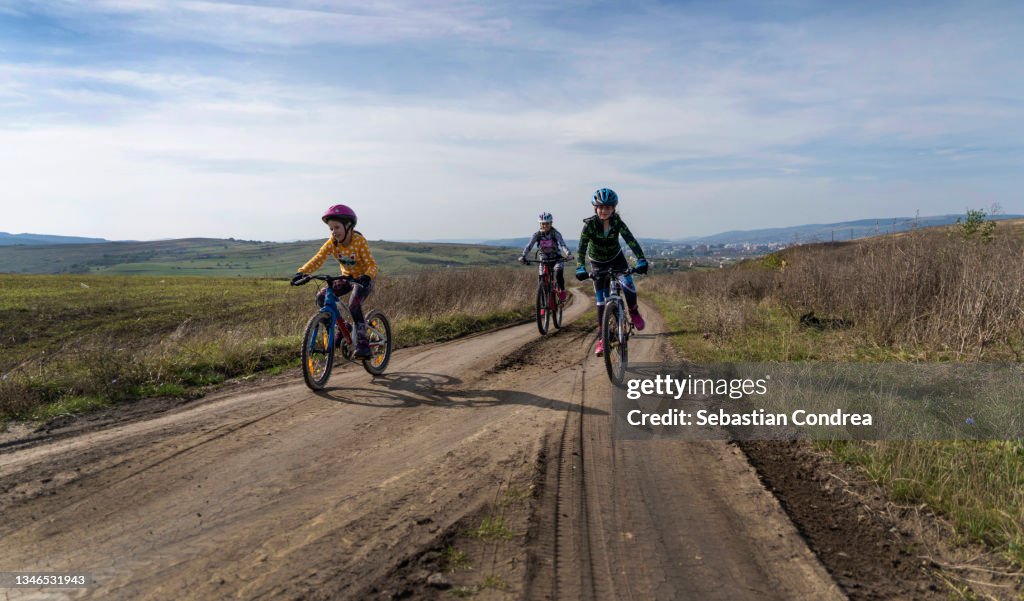 Family enjoying a bike trip, Mom and kids race on bikes. Mountain biker