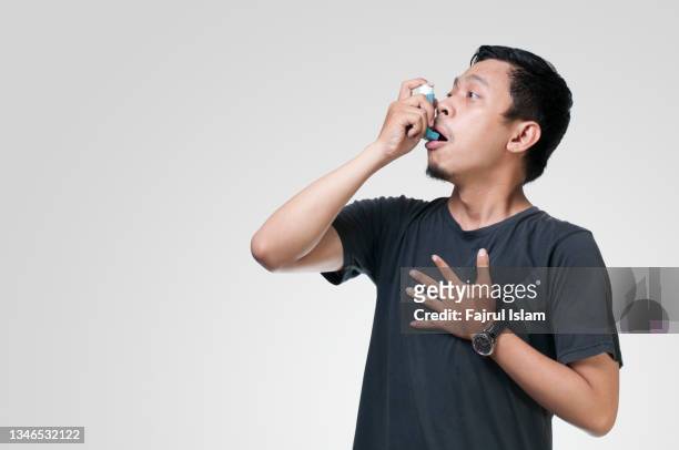 asian young men using inhaler asma - chronic condition stock pictures, royalty-free photos & images