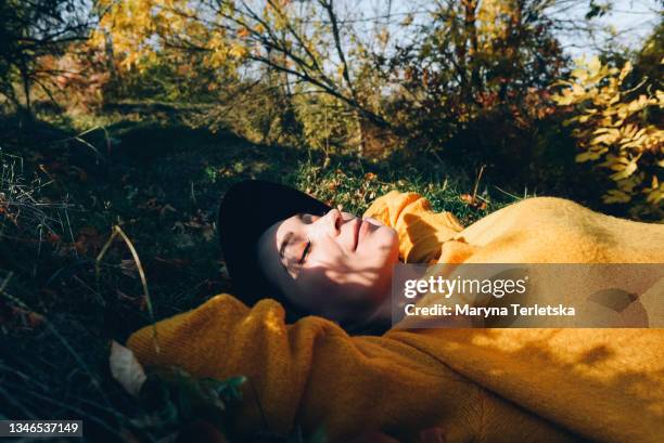 beautiful woman lies on the grass with closed eyes. - woman fresh air photos et images de collection