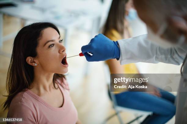 sampling from the throat. - saliva stock pictures, royalty-free photos & images