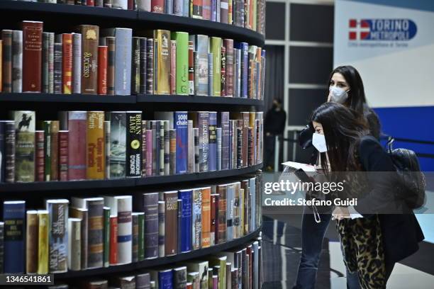 People stand near of column of books during of the Turin International Book Fair on October 14, 2021 in Turin, Italy. The Turin International Book...