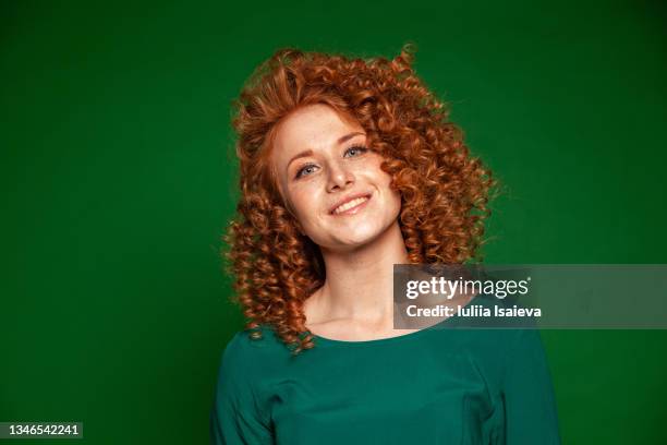 cheerful redhead woman in green dress in studio - dyed red hair 個照片及圖片檔