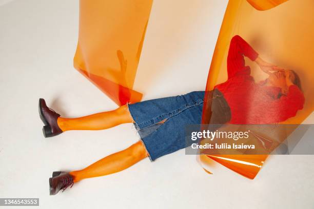 frustrated woman lying on floor in studio - women wearing see through clothing stockfoto's en -beelden