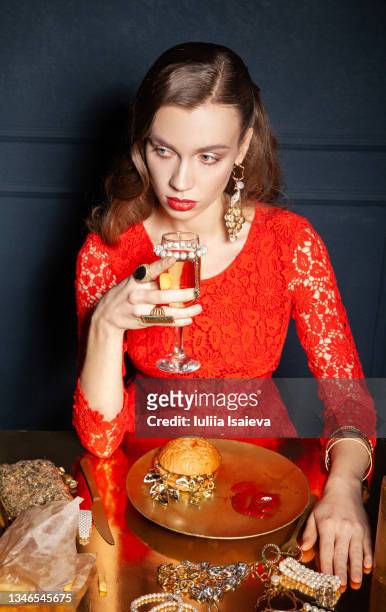 rich woman drinking champagne and eating fast food - costume jewelry fotografías e imágenes de stock