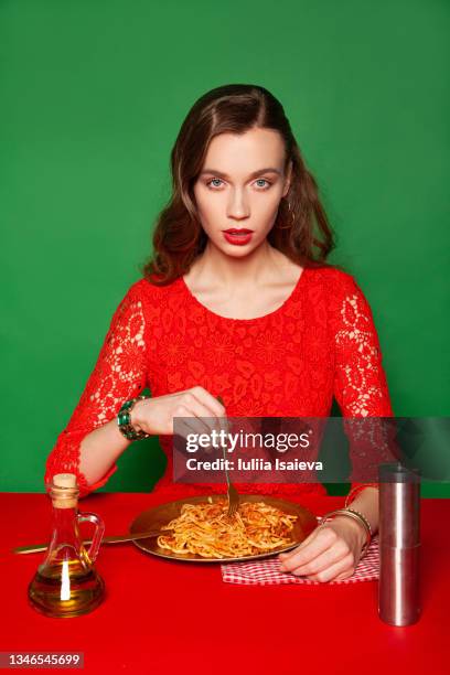 stylish woman in red dress eating spaghetti - red dress ストックフォトと画像