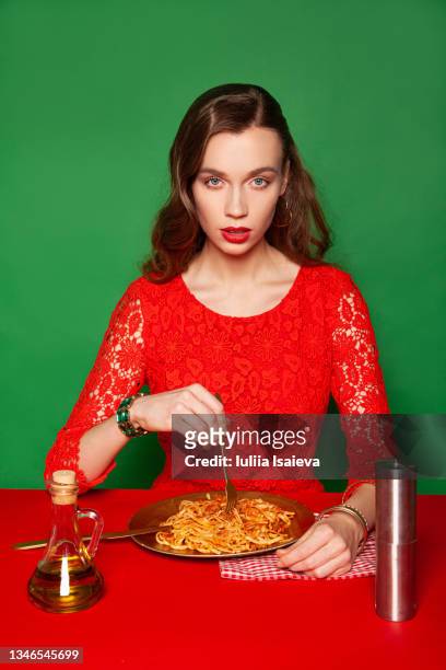 stylish woman in red dress eating spaghetti - woman eat noodles imagens e fotografias de stock