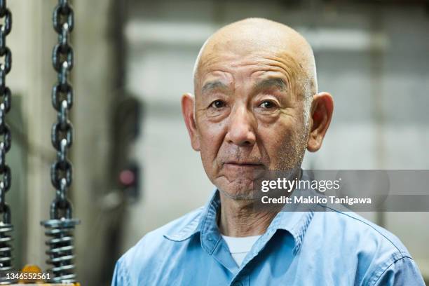 portrait of a senior male welder in a small welding factory - japanese old man foto e immagini stock