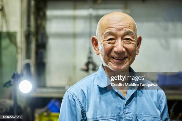 portrait of a senior male welder in a small welding factory - coveralls ストックフォトと画像