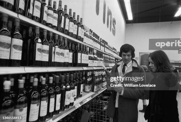 People shopping for wine at a supermarket in Calais, France, UK, November 1974.