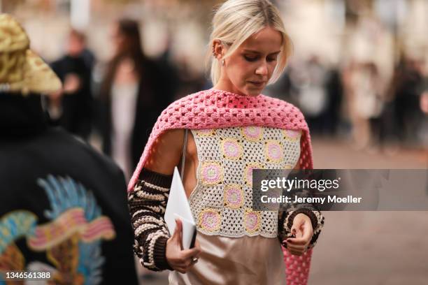 Fashion Week Guest wearing a rose dress with details and a pink scarf outside Miu Miu Show on October 05, 2021 in Paris, France.