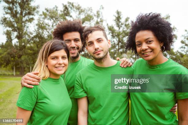 smiling climate activists in public park - green tee stock pictures, royalty-free photos & images