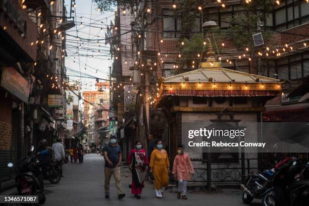 Nepali residents walk through the Thamel tourist district on October 14, 2021 in Kathmandu, Nepal. Nepal's tourism industry, heavily reliant on...