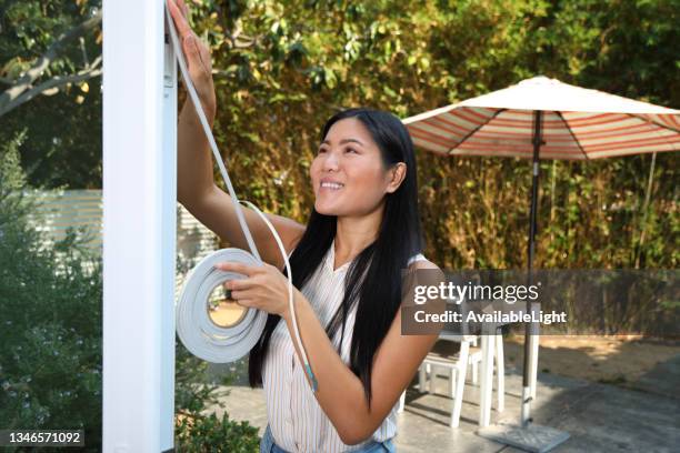 asian woman weatherstripping ms - weather stripping stock pictures, royalty-free photos & images