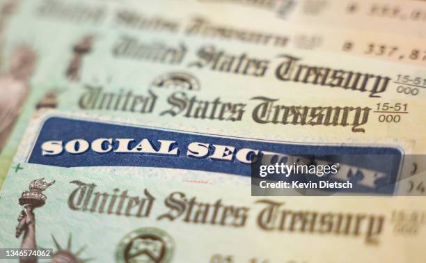 In this photo illustration, a Social Security card sits alongside checks from the U.S. Treasury on October 14, 2021 in Washington, DC. The Social...