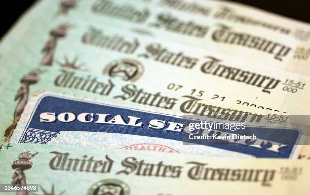 In this photo illustration, a Social Security card sits alongside checks from the U.S. Treasury on October 14, 2021 in Washington, DC. The Social...