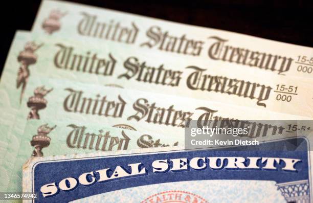 In this photo illustration, a Social Security card sits alongside checks from the U.S. Treasury on October 14, 2021 in Washington, DC. The Social...