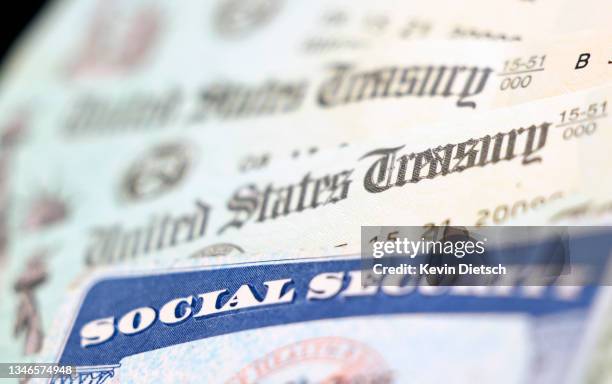 In this photo illustration, a Social Security card sits alongside checks from the U.S. Treasury on October 14, 2021 in Washington, DC. The Social...